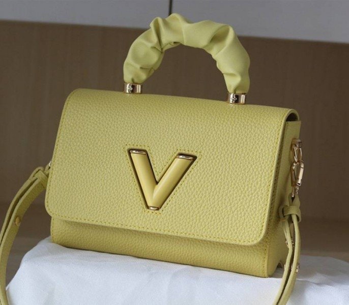 Reference image illustrating Replica Louis Vuitton Twist MM Scrunchie Handle in Ginger Yellow Taurillon Leather