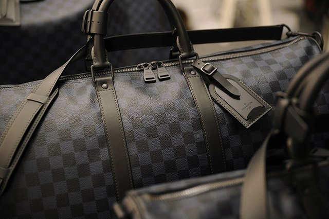 Reference image illustrating Louis Vuitton Men's Fall 2014 Runway: Damier Cobalt Canvas & Crocodile Keepall Bags